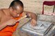 Thailand: Monk working on a silver Manchester United shield, Wat Meun San, Chiang Mai, northern Thailand