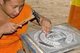 Thailand: Monk working on a silver Manchester United shield, Wat Meun San, Chiang Mai, northern Thailand